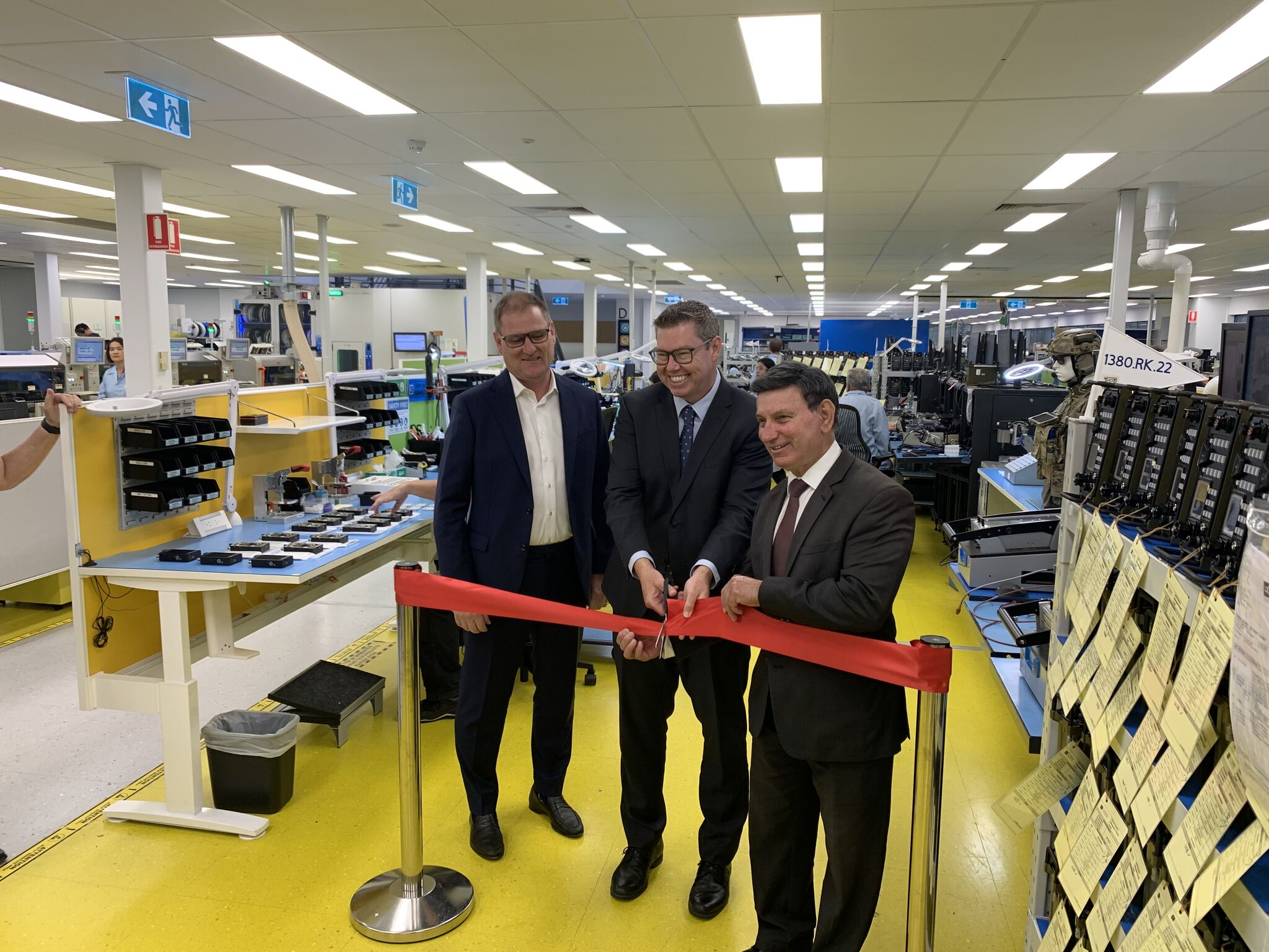 Three people cutting a ribbon ahead of a product announcement in Adelaide