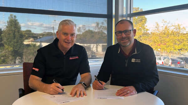 Representatives from REDARC Defence & Space and Projects Unlimited signing a teaming agreement to enhance defence collaboration.