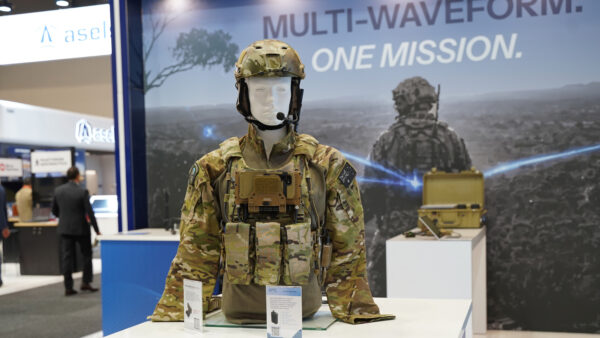 A mannequin displays military camouflage and tactical radio communications equipment.